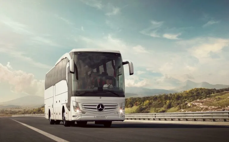 Şehirler arası yolda ilerleyen kiralık Mercedes Travego otobüs